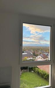 a window with a view of a house at Haus am Vogesenblick - Ihr Zimmer mit Aussicht für bis zu 3 Personen in Bad Bellingen +3 photos