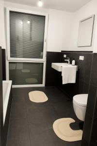 a bathroom with a sink toilet and a window at Haus am Vogesenblick - Ihr Zimmer mit Aussicht für bis zu 3 Personen in Bad Bellingen