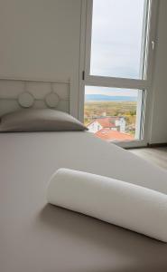 a white bed in a room with a large window at Haus am Vogesenblick - Ihr Zimmer mit Aussicht für bis zu 3 Personen in Bad Bellingen