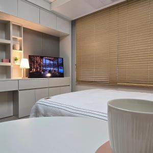 a bedroom with a bed and a flat screen tv at 원 스테이 광명역 in Gwangmyeong