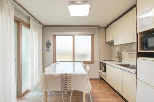 cocina con mesa blanca y ventana en Jeju Aewolae Hyuyang Pension, en Haga-ri 87 fotos más