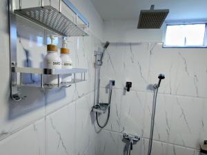 a bathroom with a shower with two bottles on a shelf at The Whitegates Lodge in Weligama