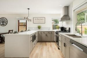 una cucina con piano di lavoro bianco e lavandino di Modern Nest - Cozy & Free Parking a Edgewood