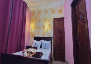 a bedroom with a bed with a dog on it at NEFAR PALACE HOTEL Plc in Bafoussam