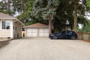 una macchina blu parcheggiata di fronte a un garage di Modern Nest - Cozy & Free Parking a Edgewood