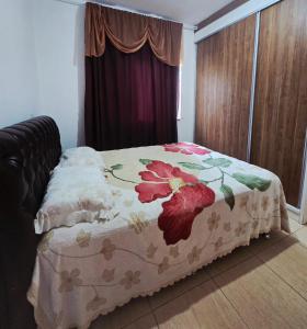 a bedroom with a bed with a flower pattern on it at Recanto do Sossego in Barra Velha