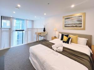 a bedroom with a large white bed and a desk at Convenient Loft Modern Stay Central Box Hill in Box Hill