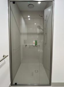 a shower with a glass door in a bathroom at Convenient Loft Modern Stay Central Box Hill in Box Hill