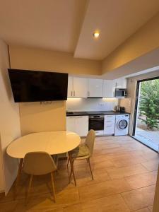 a kitchen with a table and a tv on a wall at sea soul house in Athens
