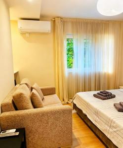 a room with two beds and a couch and a window at sea soul house in Athens