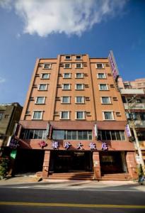 a tall brown building with signs on it at Ying Zhen Hotel in Taoyuan