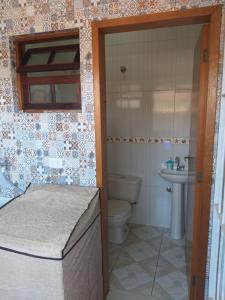 a bathroom with a toilet and a sink at Casa Temporada Bertioga- Indáia in Bertioga +105 photos