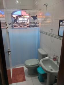 a bathroom with a toilet and a sink at Casa Temporada Bertioga- Indáia in Bertioga