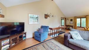 a living room with a couch and a flat screen tv at Dean Hill Chalet in Killington