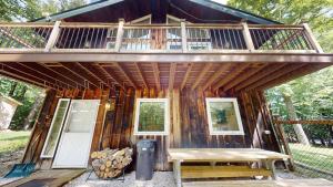 a cabin with a deck and a bench and a porch at Dean Hill Chalet in Killington