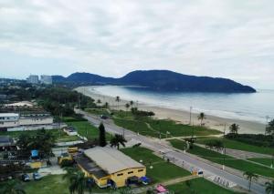 a view of a beach with a building and a road at Casa Temporada Bertioga- Indáia in Bertioga