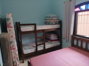 a room with a bunk bed and a shelf with towels at Casa Temporada Bertioga- Indáia in Bertioga