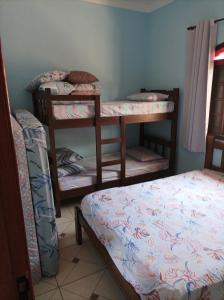 a room with two bunk beds and a bed at Casa Temporada Bertioga- Indáia in Bertioga