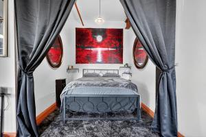 Un dormitorio con una cama con cortinas negras. en Beautiful 'Rose Themed' Loft Near Downtown Detroit apts, en Detroit