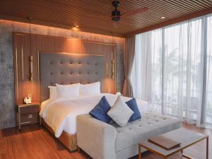 a bedroom with a large bed and a couch at Aqua Vista Hoi An Beachfront Villas in Dien Ban +53 photos