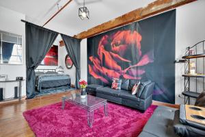 sala de estar con sofá y alfombra rosa en Beautiful 'Rose Themed' Loft Near Downtown Detroit apts, en Detroit