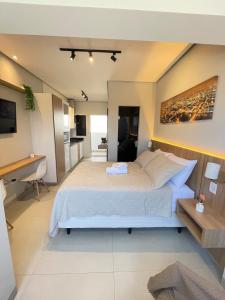 a bedroom with a large bed and a desk at Flat Executivo, Moderno e Aconchegante - Ahava Stays in Montes Claros