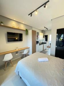 a bedroom with a bed and a desk in it at Flat Executivo, Moderno e Aconchegante - Ahava Stays in Montes Claros