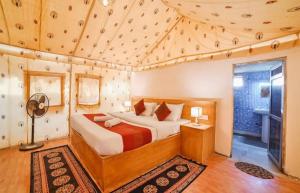 ジャイサルメールにあるDunes Villa Desert Campの部屋の中に大きなベッドがある寝室
