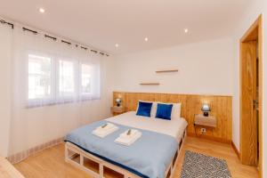 a bedroom with a large bed with blue pillows at LS Beach House in A dos Cunhados