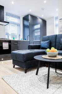 a living room with a couch and a bowl of fruit on a table at The Rye Retreat - 1BR Modern Design with Smart TV & Secure Underground Parking in Central High Wycombe HP13, Sleeps 3 in High Wycombe