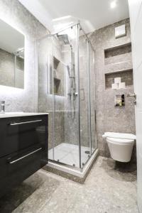 a bathroom with a glass shower and a toilet at The Rye Retreat - 1BR Modern Design with Smart TV & Secure Underground Parking in Central High Wycombe HP13, Sleeps 3 in High Wycombe +43 photos