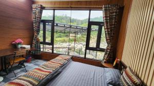 a room with a bed and a desk and a window at Thac so 6 homestay in Ha Giang