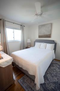 una camera da letto con un grande letto bianco e una finestra di Charming Getaway Make Memories a Sterling Heights