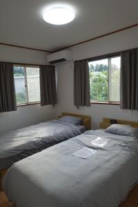 una camera da letto con due letti e due finestre di Nikko - House - Vacation STAY 38699v a Ōsawa