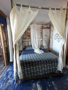 a bedroom with a canopy bed with curtains at Máncora Beach apartment in Máncora +10 photos