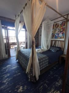 a bedroom with a canopy bed with curtains at Máncora Beach apartment in Máncora