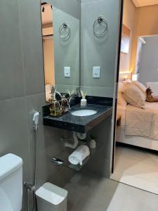 a bathroom with a sink and a mirror at Flat Executivo, Moderno e Aconchegante - Ahava Stays in Montes Claros +44 photos