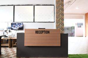 ブバネーシュワルにあるHotel O Cosmopolis Bhubaneswar Formerly Luxury Stayの「受付」と書かれた看板のある受付デスクのあるオフィス