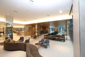 a lobby with a couch and chairs and tables at Seohaemaroo Youthhostel in Hwaseong