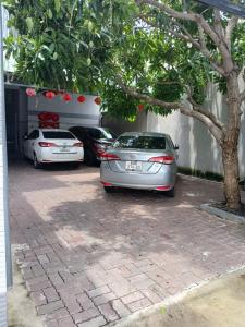 two cars parked in a parking lot under a tree at Thiên Thanh Long Hải Motel in Long Hai