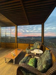 a living room with couches and a table and a view at Morada Zion Serra in Bom Jardim da Serra +26 photos