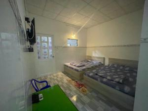 a room with two beds and a green table at Thiên Thanh Long Hải Motel in Long Hai