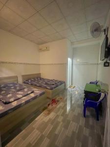 a room with two beds and a chair in it at Thiên Thanh Long Hải Motel in Long Hai