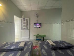 a room with two beds and a table and a tv at Thiên Thanh Long Hải Motel in Long Hai +19 photos
