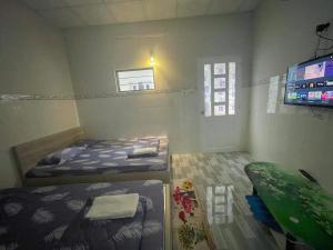 隆海Thiên Thanh Long Hải Motel的小房间设有两张床和电视