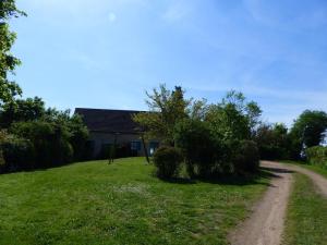 a house in a field with a dirt road at Gîte familial avec jardin clos, proche Forêt de Tronçais - FR-1-489-238 in Le Brethon