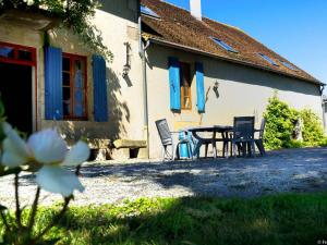 a table and chairs in front of a house at Gîte à la Ferme avec Piscine et Wifi à Souvigny - FR-1-489-231 in Souvigny