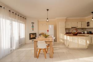 a kitchen with white cabinets and a table and chairs at LS Beach House in A dos Cunhados +33 photos