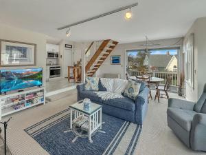 Una sala de estar con un sofá azul y un televisor en Perkins Cove Gem - Q934 Brought to you by GetAway Vacations, en Ogunquit