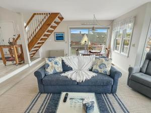Una sala de estar con un sofá azul y una escalera. en Perkins Cove Gem - Q934 Brought to you by GetAway Vacations, en Ogunquit